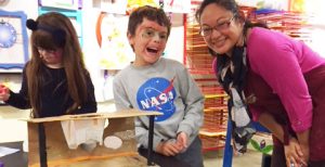 Educator helping boy and girl with an art project in our Art Studio